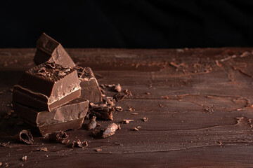 Organic food snack tasty sweet dessert milk dark chocolate bar macro closeup broken slide piece and fruit orange raspberry hazelnut nuts on cocoa cacao powder wooden table for new year Christmas gift