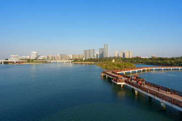 Landscapes of Xiamen Wuyuanwan Natural Park and Wuyuan Bridge in distance with water foreground and Xiamen city skyline