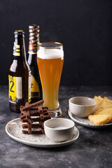 Aromatic snacks, toasts with garlic sauce and fried cheese in breading are served with fresh beer