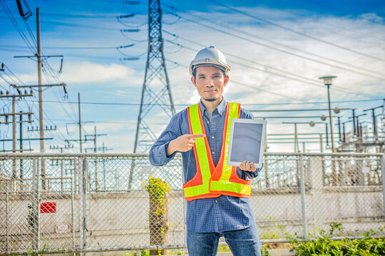 Electrical engineer hold tablet at high volte station