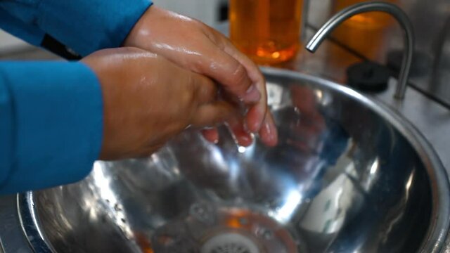 Young Man Washing His Hands On The Back Of A Restaurant - Cook Washing Hands-on Kitchen Restaurant