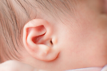 Caucasian Newborn baby ear closeup macro detail shot. child portrait, health skin, tenderness, maternity and babyhood concept. Soft selective focus