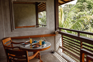 Beautiful cozy luxury breakfast for two  on the balcony of hotel room with tropical jungle view