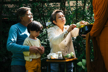 Family give alms offering to buddhist monk in the morning.