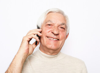 Technology, senior people, lifestyle and communication concept - close up of happy old man using smartphone over white background.
