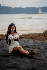 beautiful woman sitting on the black beach