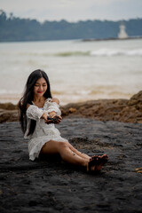 beautiful woman sitting on the black beach