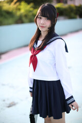 Portrait of Asian schoolgirl looking with blue stadium background