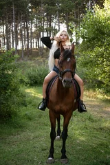 Foto op Canvas Beautiful woman stands with a horse in nature on the background of the forest © Екатерина Переславце