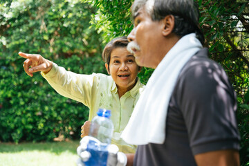 Cheerful funny senior couple exercise at park.