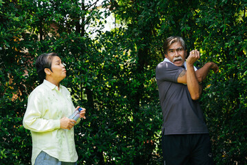 Asian senior elderly warm up before exercise together at yard.