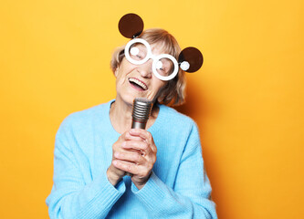 Lifestyle, emotion and old people concept: Happy elderly woman wearing big sunglasses amd holding a...