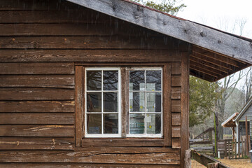 Couple of windows on an old wooden house.