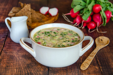 Summer cold soup okroshka. Traditional Russian soup okroshka with kvass, radish, cucumbers, eggs, sausage, green onions and sour cream. Famous Russian dishes. 