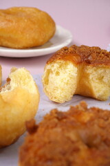 Grainy Donat or Donut or Doughnut with caramel and Lotus biscuit crumbs. Selective focus, pink pastel background