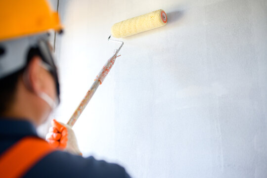 Young Asian Painters Have The Joy Of Painting Interior White Walls With Paint Roller In New House.