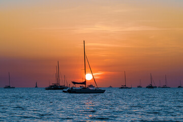 Sailing boats at Vesteys beach at sunset in Darwin, Australia.