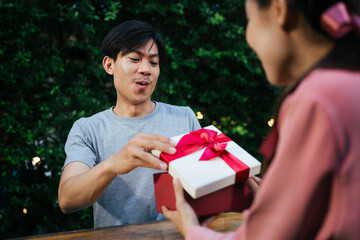 Asian man get a gift box from girlfriend in valentine day.