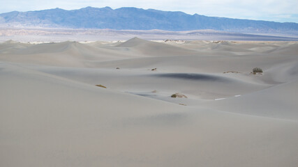Fototapeta na wymiar Sand Dunes in Death Valley National Park with Mountains in Background