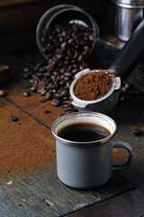 coffee bean cup and porta filter with coffee powder inside and Vietnam Drip Coffee on wooden table
