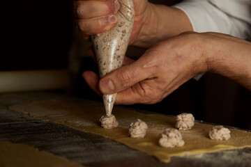 Making ravioli, stuffed with chestnut, hand with piping bag