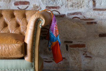 Interior design leather sofa with scarf, wall in brick and stone