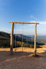 Fototapeta na wymiar Old wooden swing View on a mountain in Nan Province, Rai Hom Mok