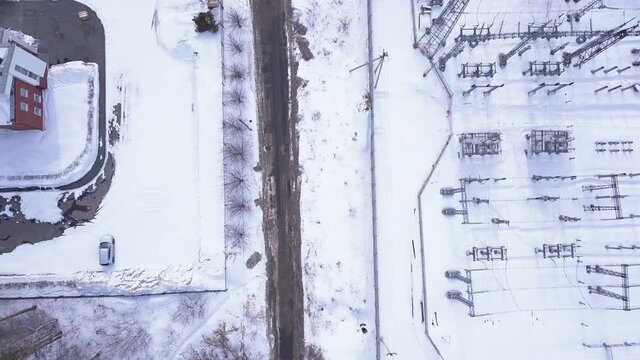 Rows of electric poles of substation. Action. Top view of small electrical substation with rows of transformers in suburbs. Suburban electric substation in winter
