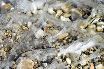 Ice with cracks on a frozen river in winter
