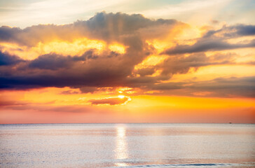 The sky and the sea with the orange sun in the evening. The sun is going to set. Orange sky background.