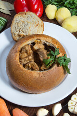 A traditional dish of Russian cuisine meat in a pot of bread. Restaurant serving concept. Close-up.