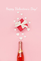 White hearts, bottle of wine and gift box on pink background. Valentines day concept. Flat lay, top view, copy space.