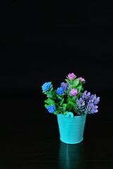 Plastic flowers in a small Tosca colored metal basket
