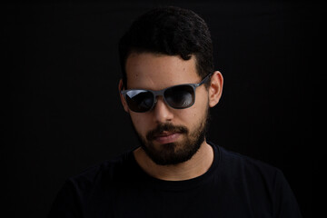 Portrait of a young man in a studio shot. He is caucasian with casual beard and is serious looking...