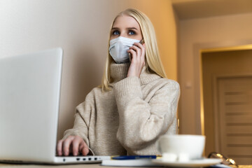 Girl sitting at the computer and talking on the phone