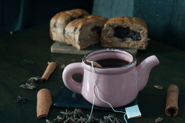 A cup of teabag with grated bread on a wooden chopping board decorated with cinnamon and star