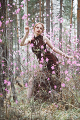 Japanese-style girl in a flowering forest among pink flowers in spring