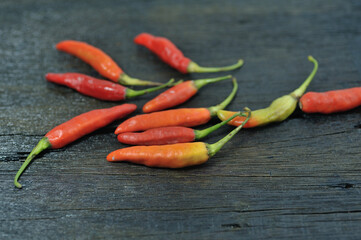 A few red chilies on a full black wooden base