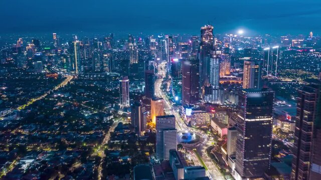 Stunning City View of Futuristic Skyline at Night, Skyscrapers in Asian Indonesian Capital Jakarta with flashing lights and Car Traffic Flow on Main road, Aerial Hyperlapse Time Lapse, Drone View