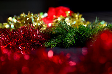 Orange beads with round beads to decorate the Christmas tree, close-up against a background of blurred red light from the lamps. 