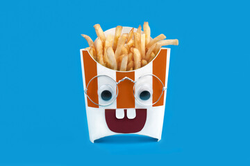 food photography of carton box with french fries (fried potatoes, fastfood) front view stylized as a teenager nerd with glasses on a blue background isolated close up
