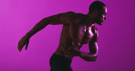 Fit athlete working out on purple background