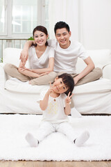 Young Chinese girl in a living room with parents in the background