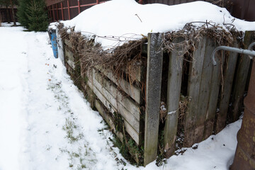 Very large three section wooden compost box standing garden in winter at countryside for ecological...