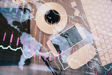 Multi exposure of forex graph hologram over desktop with phone. Top view. Mobile trade platform concept.