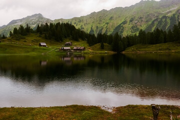 Obraz premium houses on the shore from a mountain lake while hiking