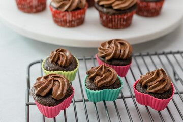 Mini chocolate cupcakes in heart-shaped silicon baking molds close up on cooling rack