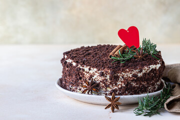 Layered chocolate cake decorated with red heart, rosemary, cinnamon and anise. Russian honey cake, Medovik.