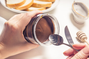 Hands opening bottle of chocolate butter