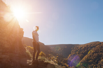 man on the background of a yellow forest on a mountainside on a clear day, sunlight, sun glare.